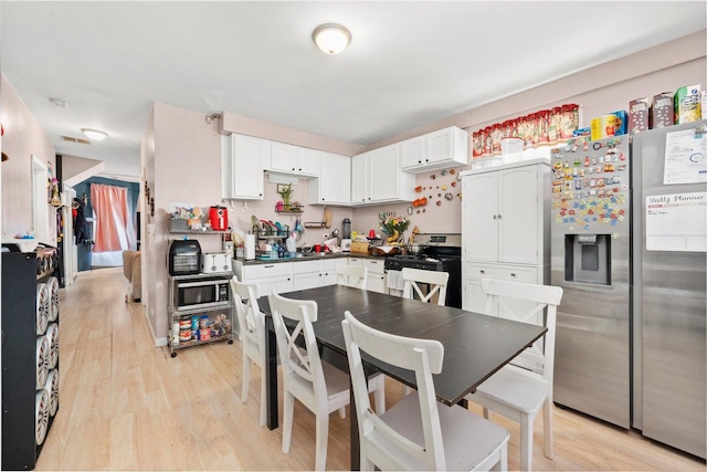 3034 S Komensky Ave, Chicago, IL 60623 - kitchen featuring appliances with stainless steel finishes, light wood-type flooring, white cabinetry, and dark countertops