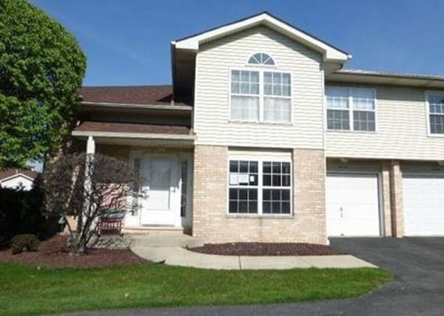 7254 Terrace Dr Unit 47, Justice, IL 60458 - view of front of house featuring asphalt driveway, brick siding, and a garage