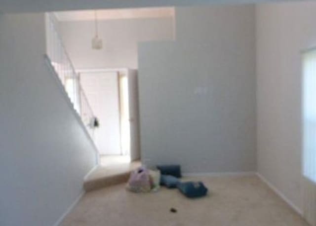 7254 Terrace Dr Unit 47, Justice, IL 60458 - spare room with stairway, healthy amount of natural light, carpet floors, and baseboards