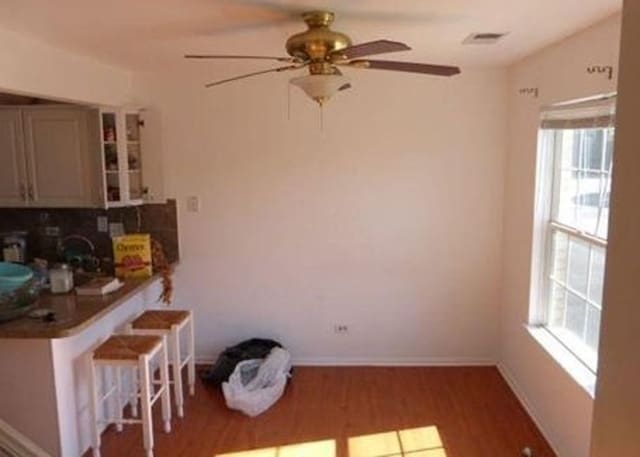 7254 Terrace Dr Unit 47, Justice, IL 60458 - dining area featuring ceiling fan, plenty of natural light, wood finished floors, and baseboards