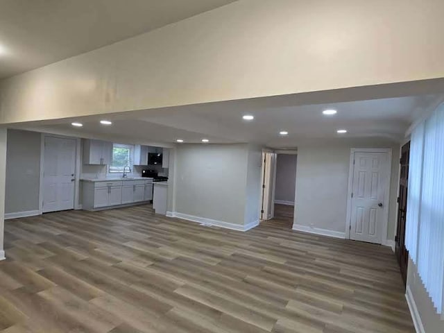 2524 Gray Ct, Waukegan, IL 60085 - unfurnished living room with wood finished floors, a sink, baseboards, recessed lighting, and a towering ceiling