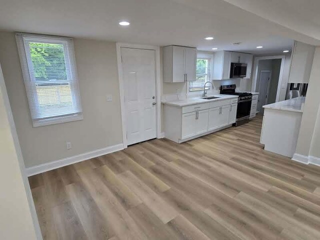 2524 Gray Ct, Waukegan, IL 60085 - kitchen featuring appliances with stainless steel finishes, a sink, baseboards, light wood-type flooring, and recessed lighting