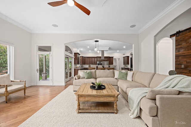 4103 Douglas Rd, Downers Grove, IL 60515 - living room featuring arched walkways, light wood finished floors, a ceiling fan, a barn door, and ornamental molding