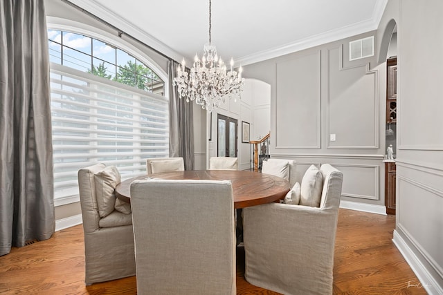 4103 Douglas Rd, Downers Grove, IL 60515 - dining room featuring arched walkways, a chandelier, wood finished floors, stairway, and ornamental molding