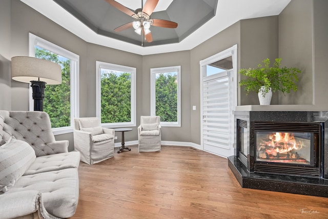 4103 Douglas Rd, Downers Grove, IL 60515 - sitting room featuring wood finished floors, a glass covered fireplace, ceiling fan, and a raised ceiling