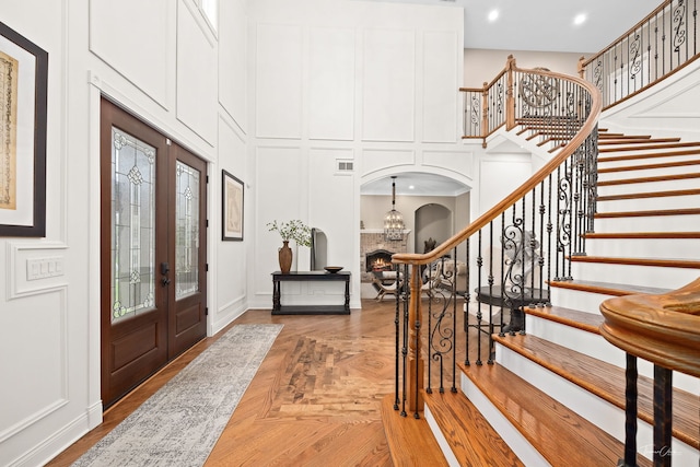 4103 Douglas Rd, Downers Grove, IL 60515 - foyer featuring arched walkways, a decorative wall, stairway, a high ceiling, and french doors