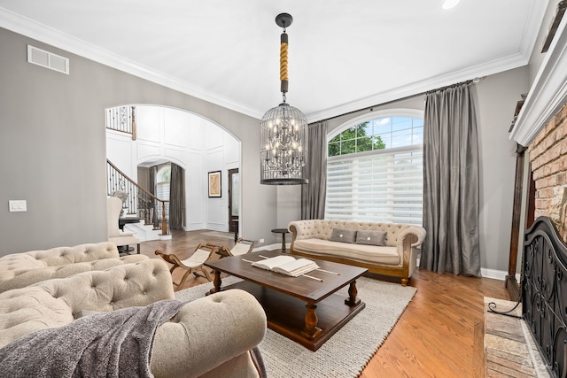 4103 Douglas Rd, Downers Grove, IL 60515 - living room with arched walkways, crown molding, stairs, light wood-style flooring, and a chandelier
