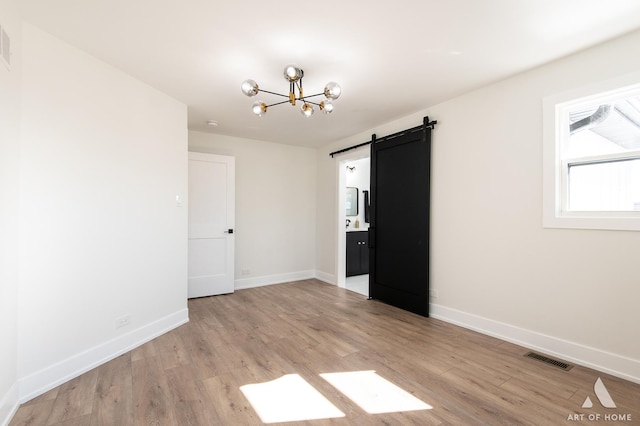 9859 S 81st Ave, Palos Hills, IL 60465 - spare room with a barn door, a chandelier, light wood finished floors, and baseboards