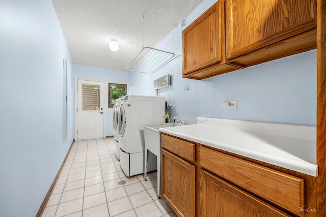 2734 Alyssa Dr, Naperville, IL 60565 - laundry area featuring cabinet space, washer and clothes dryer, light tile patterned floors, and a textured ceiling