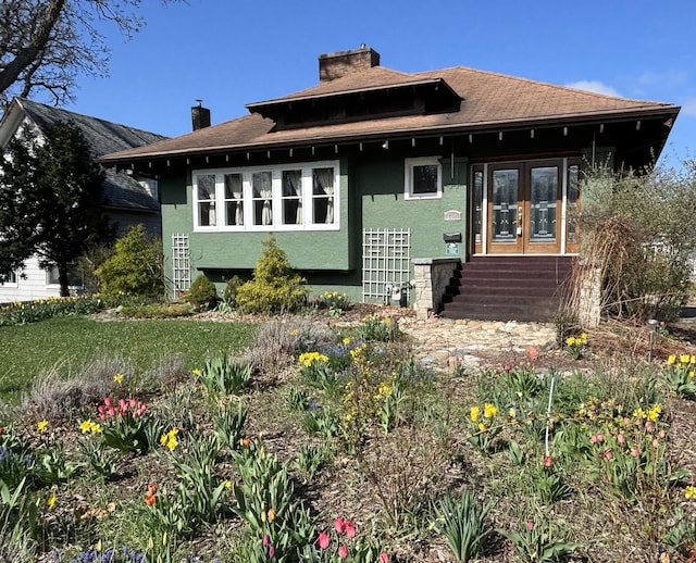 704 N Division St, Harvard, IL 60033 - view of front of home with a chimney, french doors, entry steps, and stucco siding