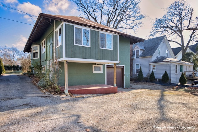 704 N Division St, Harvard, IL 60033 - view of front of property with dirt driveway, a garage, and stucco siding