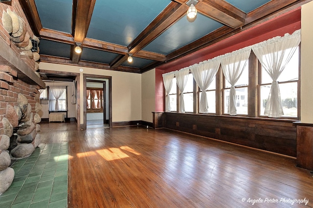 704 N Division St, Harvard, IL 60033 - unfurnished living room with radiator, beam ceiling, healthy amount of natural light, wood finished floors, and coffered ceiling