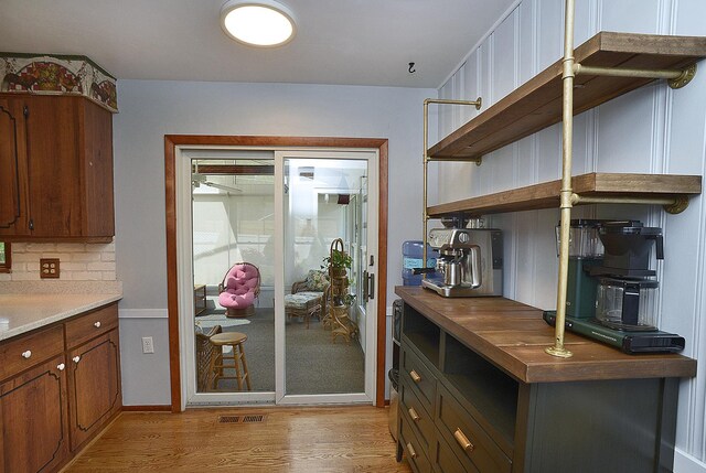 731 Marcy St, Ottawa, IL 61350 - kitchen with open shelves, light wood-style flooring, backsplash, and brown cabinetry