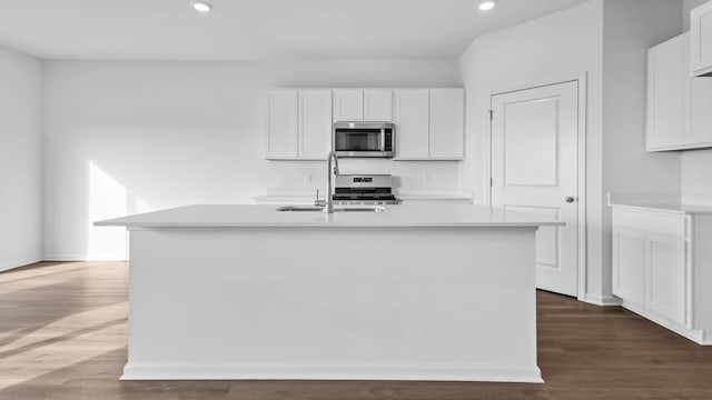 kitchen with stainless steel appliances, a sink, light countertops, white cabinets, and recessed lighting