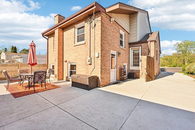 8252 N Caldwell Ave, Niles, IL 60714 - back of house featuring a patio area, a chimney, and brick siding
