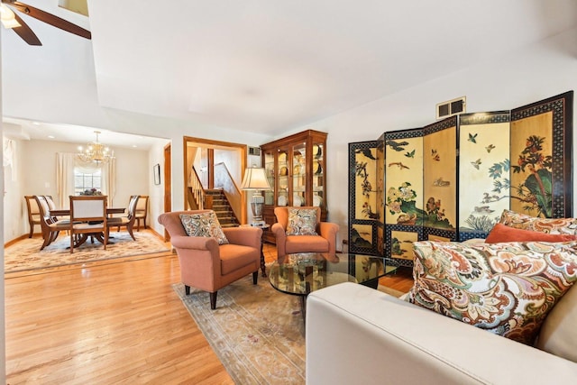 8252 N Caldwell Ave, Niles, IL 60714 - living room with light wood finished floors, a chandelier, stairs, and ceiling fan