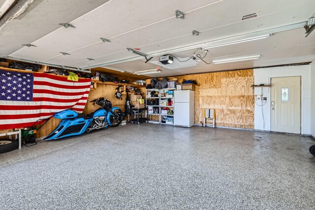 1360 Gentry Rd, Hoffman Estates, IL 60169 - garage featuring freestanding refrigerator, a garage door opener, and wood walls