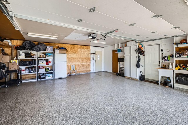 1360 Gentry Rd, Hoffman Estates, IL 60169 - garage with freestanding refrigerator, wooden walls, and a garage door opener