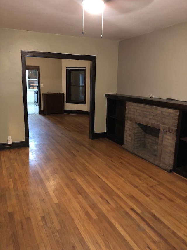 4109 W Oakdale Ave, Chicago, IL 60641 - unfurnished living room featuring wood finished floors, a fireplace, and baseboards