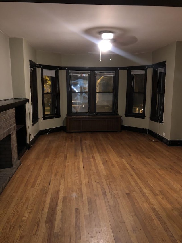 4109 W Oakdale Ave, Chicago, IL 60641 - unfurnished living room with hardwood / wood-style floors, a brick fireplace, and ceiling fan