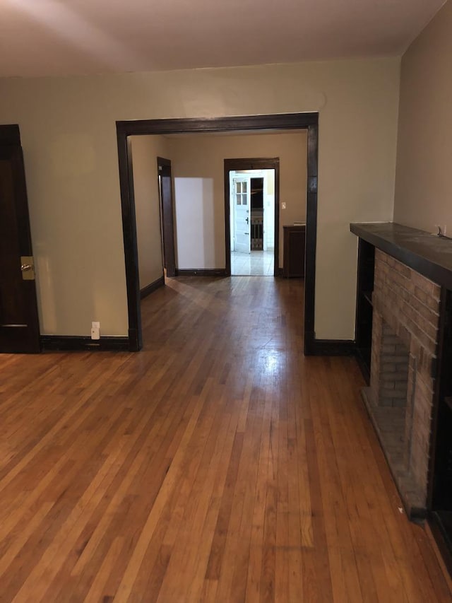 4109 W Oakdale Ave, Chicago, IL 60641 - unfurnished living room featuring a fireplace, baseboards, and hardwood / wood-style flooring