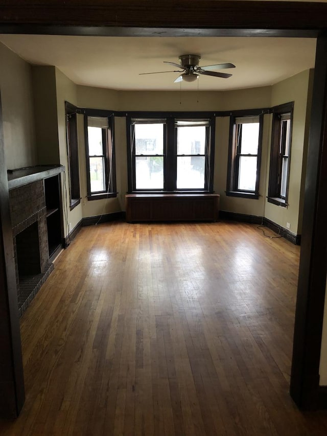 4109 W Oakdale Ave, Chicago, IL 60641 - unfurnished living room with a ceiling fan, a fireplace, hardwood / wood-style flooring, and baseboards