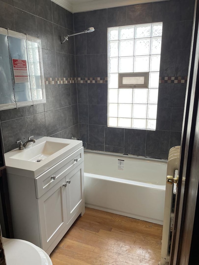 4109 W Oakdale Ave, Chicago, IL 60641 - bathroom featuring wood finished floors, vanity, shower / tub combination, tile walls, and radiator heating unit