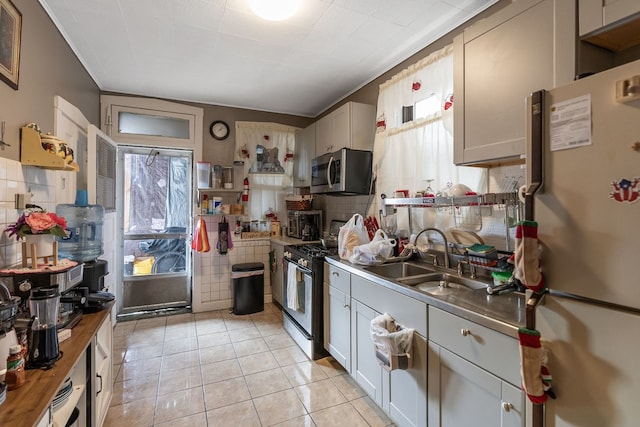 4109 W Oakdale Ave, Chicago, IL 60641 - kitchen with stainless steel appliances, a sink, decorative backsplash, and light tile patterned floors