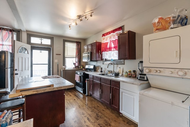 4109 W Oakdale Ave, Chicago, IL 60641 - kitchen with appliances with stainless steel finishes, a sink, estacked washer and dryer, and light countertops