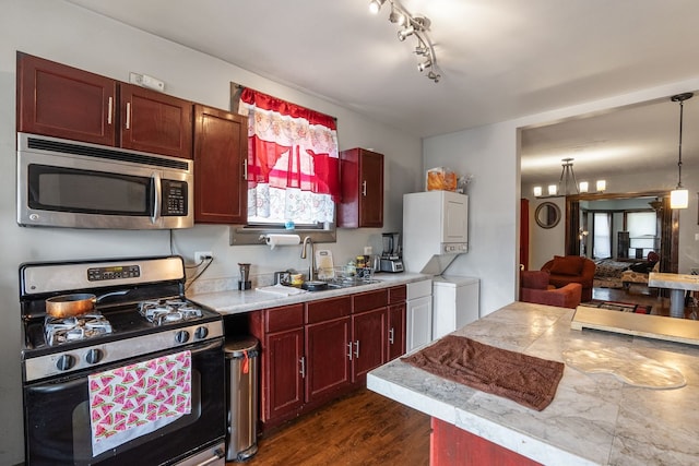 4109 W Oakdale Ave, Chicago, IL 60641 - kitchen with stainless steel appliances, a sink, stacked washer / dryer, light countertops, and dark wood-type flooring