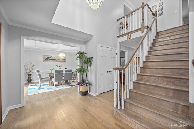 440 Cranesbill Dr, West Chicago, IL 60185 - foyer entrance with stairway, crown molding, baseboards, wood finished floors, and a chandelier