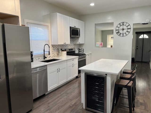 6036 S Loomis Blvd, Chicago, IL 60636 - kitchen with appliances with stainless steel finishes, beverage cooler, a sink, dark wood finished floors, and a breakfast bar area