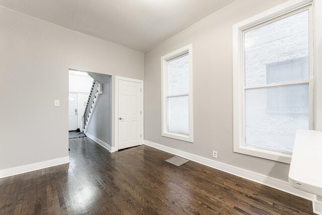 3216 W Walnut St, Chicago, IL 60624 - empty room with healthy amount of natural light, baseboards, dark wood finished floors, and stairway