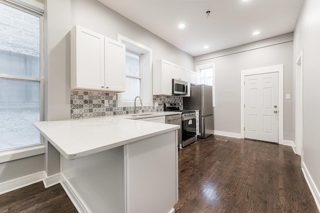 3216 W Walnut St, Chicago, IL 60624 - kitchen featuring stainless steel appliances, a sink, backsplash, white cabinets, and dark wood finished floors