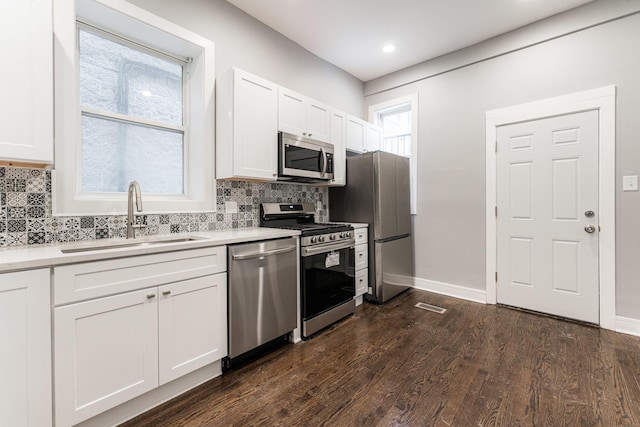3216 W Walnut St, Chicago, IL 60624 - kitchen with appliances with stainless steel finishes, a sink, backsplash, white cabinetry, and dark wood finished floors