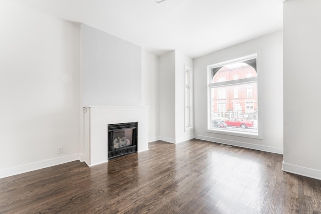 3216 W Walnut St, Chicago, IL 60624 - unfurnished living room featuring wood finished floors, a glass covered fireplace, and baseboards
