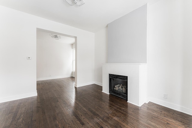 3216 W Walnut St, Chicago, IL 60624 - unfurnished living room featuring wood finished floors, a glass covered fireplace, and baseboards