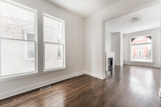 3216 W Walnut St, Chicago, IL 60624 - empty room featuring dark wood-style flooring, a fireplace, and baseboards