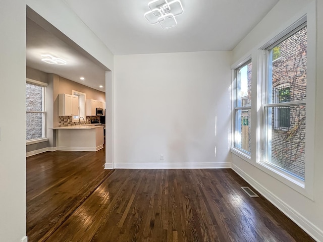 3216 W Walnut St, Chicago, IL 60624 - unfurnished dining area featuring dark wood-style floors and baseboards