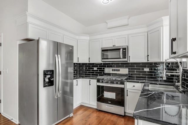 1544 Sauganash Ct, Gurnee, IL 60031 - kitchen featuring appliances with stainless steel finishes, a sink, tasteful backsplash, dark wood-type flooring, and dark stone counters
