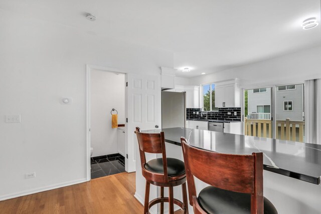 1544 Sauganash Ct, Gurnee, IL 60031 - kitchen featuring refrigerator, dishwasher, white cabinets, a kitchen bar, and backsplash