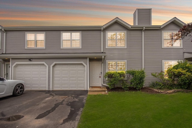 1991 Westview Ln, Round Lake Beach, IL 60073 - townhome / multi-family property featuring a front yard, an attached garage, asphalt driveway, and a chimney