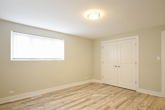 8040 S Lafayette Ave, Chicago, IL 60620 - unfurnished bedroom with light wood-style floors, baseboards, and a closet