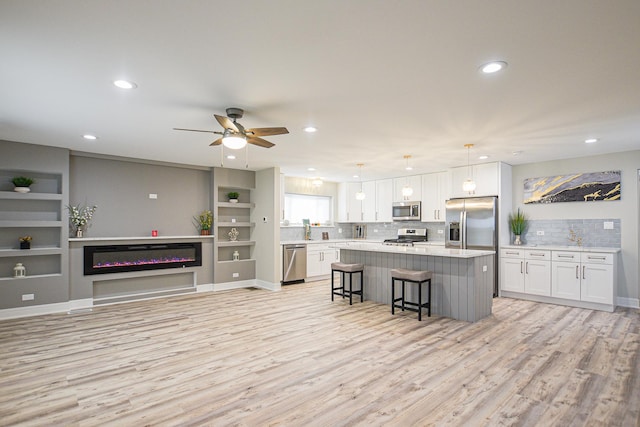 8040 S Lafayette Ave, Chicago, IL 60620 - kitchen featuring appliances with stainless steel finishes, light wood finished floors, white cabinets, a center island, and recessed lighting