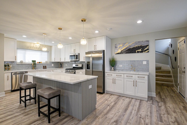 8040 S Lafayette Ave, Chicago, IL 60620 - kitchen featuring appliances with stainless steel finishes, tasteful backsplash, white cabinetry, a breakfast bar, and recessed lighting