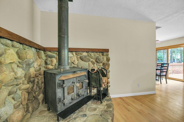 907 S Trailside Dr, Mahomet, IL 61853 - detailed view of a textured ceiling, a wood stove, and wood finished floors