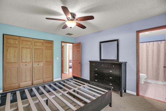 907 S Trailside Dr, Mahomet, IL 61853 - carpeted bedroom featuring a textured ceiling, ensuite bathroom, ceiling fan, and a closet