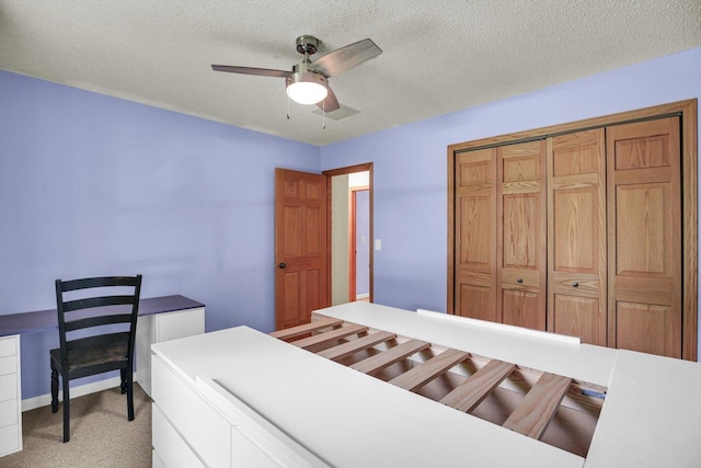 907 S Trailside Dr, Mahomet, IL 61853 - bedroom with light carpet, a textured ceiling, a ceiling fan, a closet, and a desk