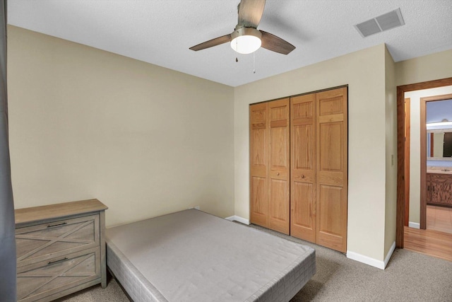 907 S Trailside Dr, Mahomet, IL 61853 - unfurnished bedroom featuring light carpet, a closet, and a ceiling fan