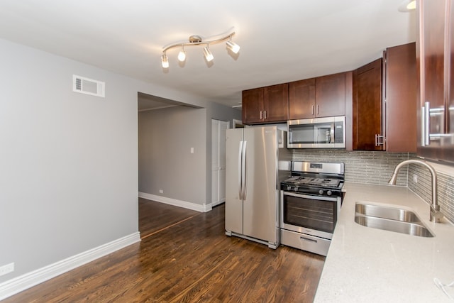 7338 S Campbell Ave, Chicago, IL 60629 - kitchen with stainless steel appliances, a sink, light countertops, dark wood-type flooring, and tasteful backsplash